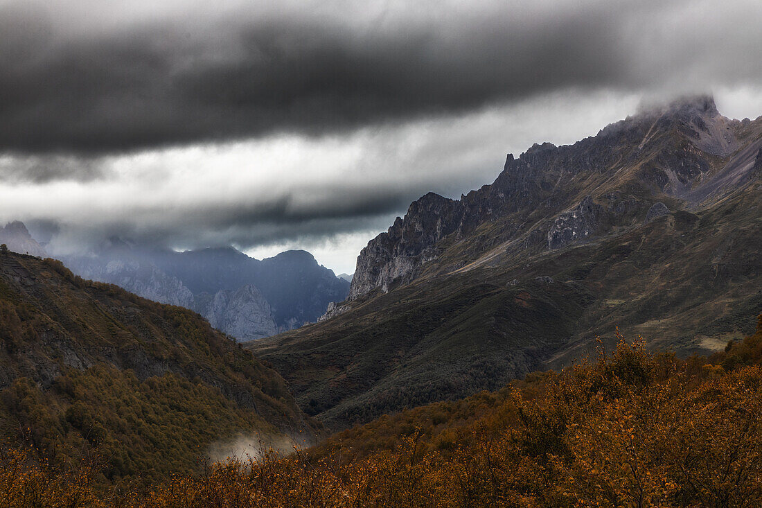 Wolken zwischen bewaldeten Berghängen und hohen Gipfeln,  Posada de Valdeón, Provinz León, Kastilien-León, Spanien