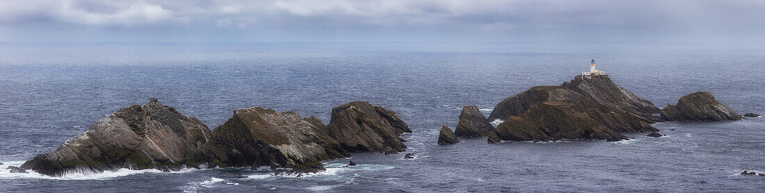  Rocky islands in the sea with the lonely lighthouse Muckla Flugga. 