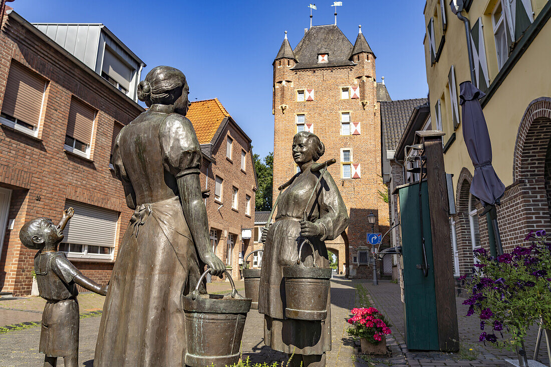  Bronze sculpture &quot;Women at the water pump&quot; and the Inner Klever Gate in Xanten, Lower Rhine, North Rhine-Westphalia, Germany, Europe 