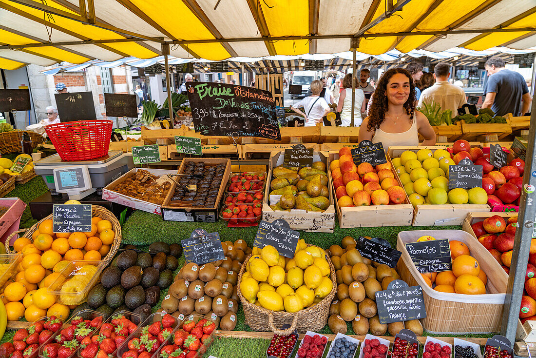 Verkäuferin an ihrem Stand mit Obst auf dem Markt in La Rochelle, Frankreich, Europa