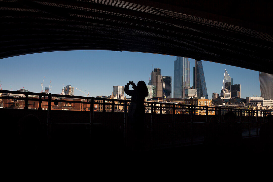 Silhouette einer Frau, die die Skyline von Westminster fotografiert, London, England, Europa