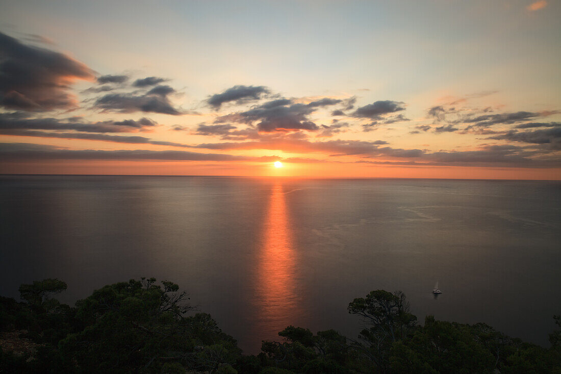 Sonnenaufgang spiegelt sich im ruhigen Meerwasser, Mallorca, Spanien