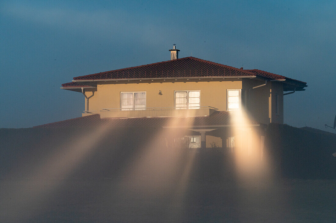  Morning mood with fog and reflection of the sun rays from the house windows, Henndorf, Salzburg, Austria 