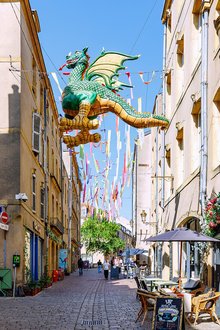  The old town street Rue Taison, decorated with colorful stripes and the legendary dragon figure Graoully (Grauli), leads to the Colline Sainte-Croix in Metz in the Moselle department in the Grand Est region of France 