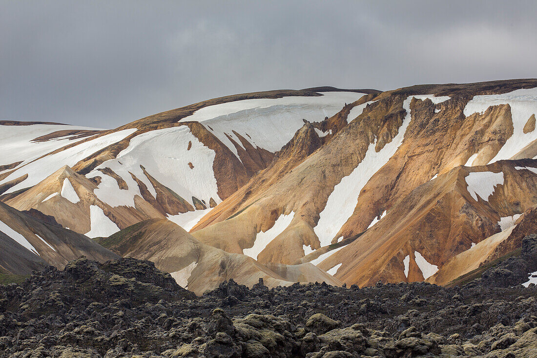  Colourful rhyolite mountains with snow remnants at Brennisteinsalda volcano in Landmannalaugar, Fjallabak National Park, Sudurland, Iceland 