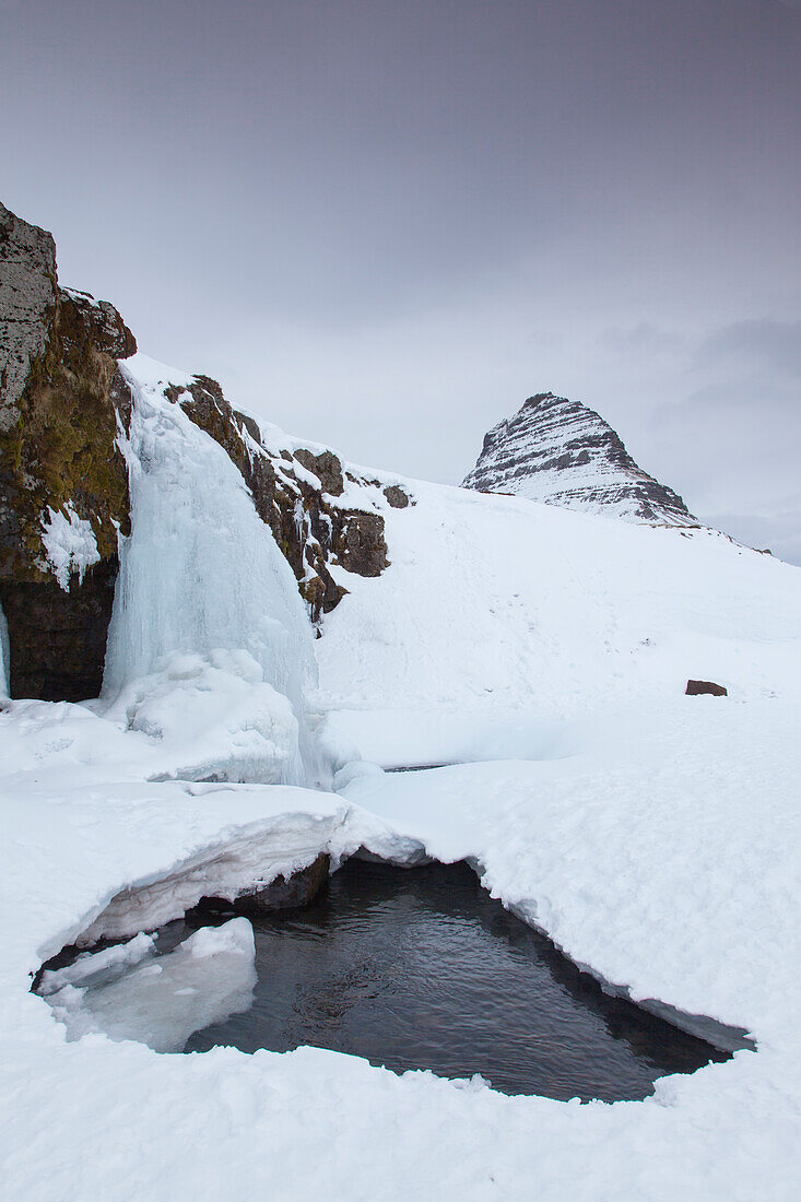  Kirkjufjell mountain with Kirkjufjellsfoss waterfall, winter, Iceland 