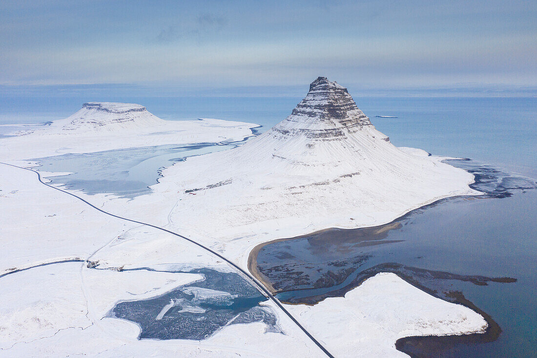 Berg Kirkjufjell am verschneiten Fjord, Winter, Island