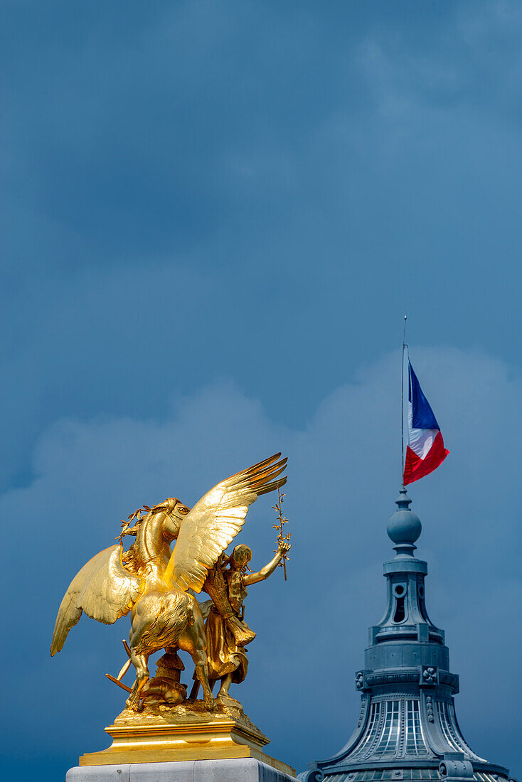  Column with the figure group &quot;Fama des Agriculturists&quot; on the bridge Pont Alexandre III over the Seine, behind it the dome of the Grand Palais with the French national flag, tricolo, Paris, Île-de-France, France, Europe 