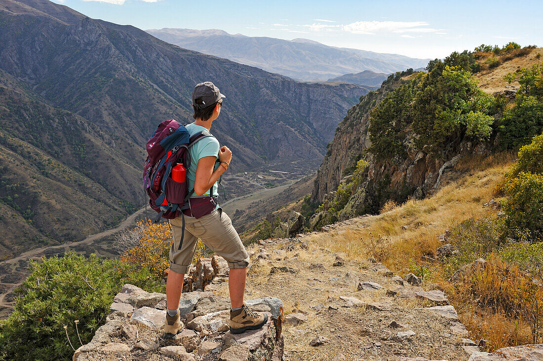 young woman standing on a defensive wall of Smbataberd Fortress, located upon the crest of a hill between the villages of Artabuynk and Yeghegis, near Yeghegnadzor, Vayots Dzor province, Armenia, Eurasia