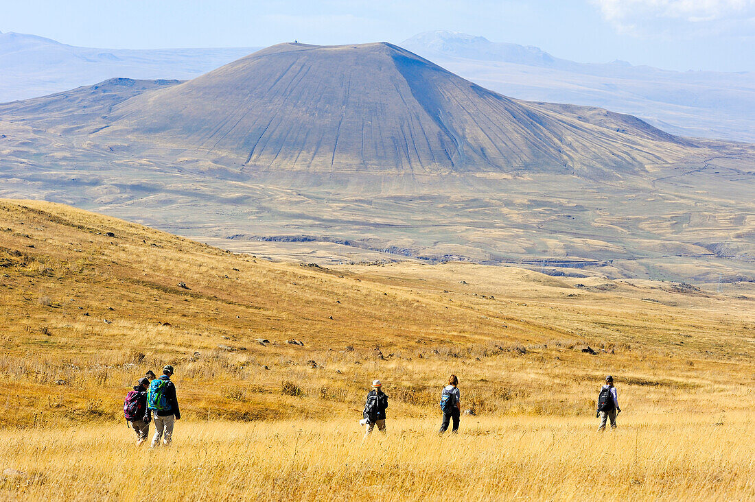 hikers on the Argitchi plateau with the Armaghan volcano in the background, Argitchi plateau, Gegharkunik region, Armenia, Eurasia