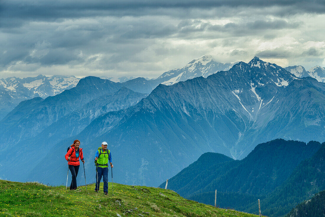  Man and woman hiking on the Pfunderer Höhenweg, Zillertal main ridge in the background, Pfunderer Höhenweg, Zillertal Alps, South Tyrol, Italy 