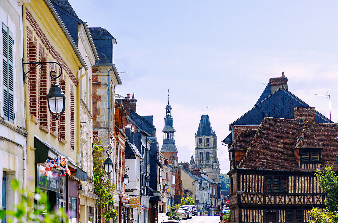  Half-timbered houses on the street Rue Grande and view of the church Église Notre-Dame in Orbec in the Pays d&#39;Auge in the department of Calvados in the region of Normandy in France 