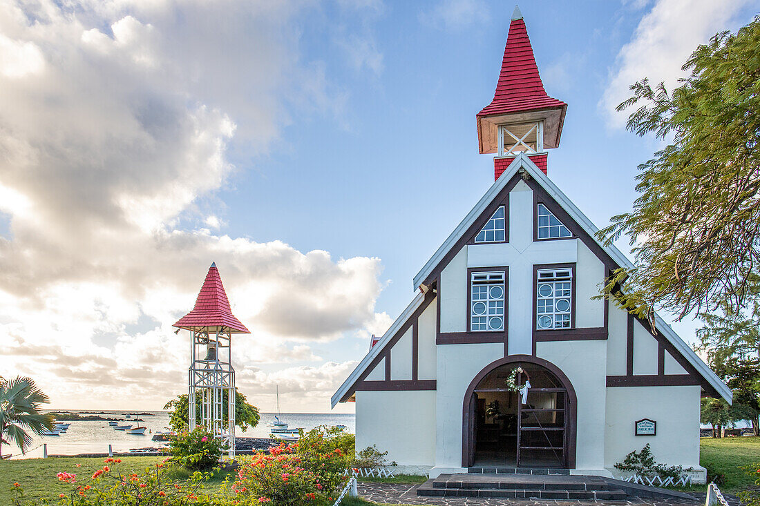  Notre-Dame Auxiliatrice de Cap Malheureux, church with red roof directly by the sea and Mauritius at sunset 