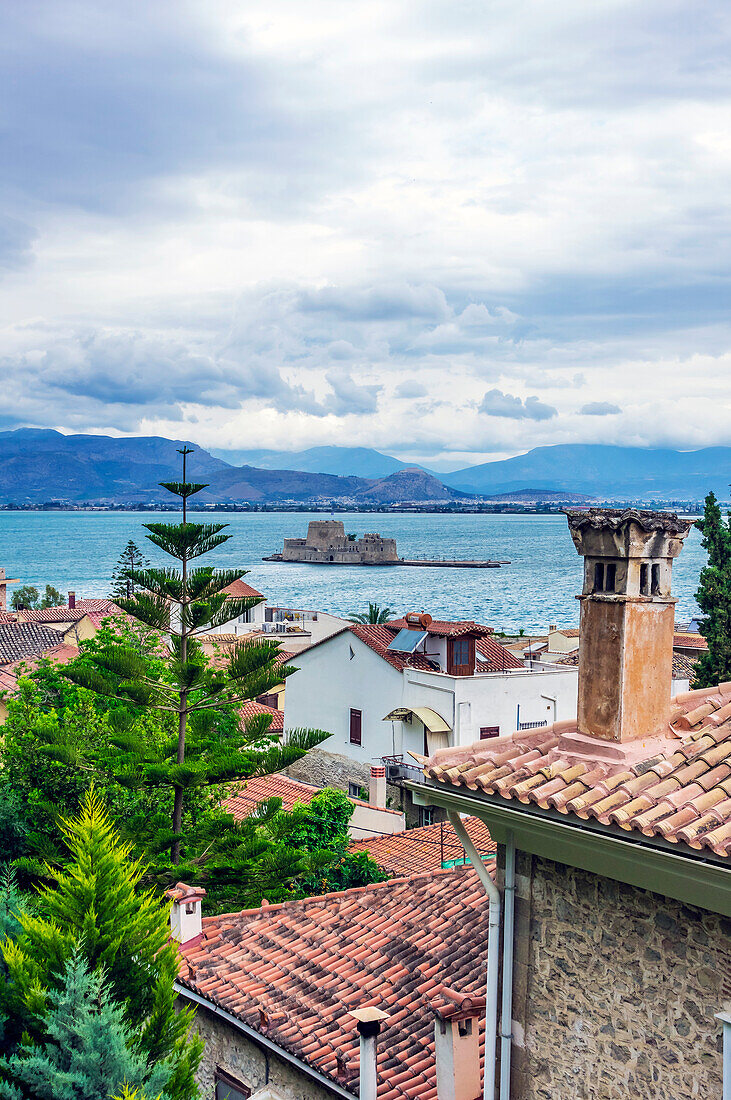  View of houses of the city of Nafplio with the fortress of Bourtzi in the background, Peloponnese, Greece 