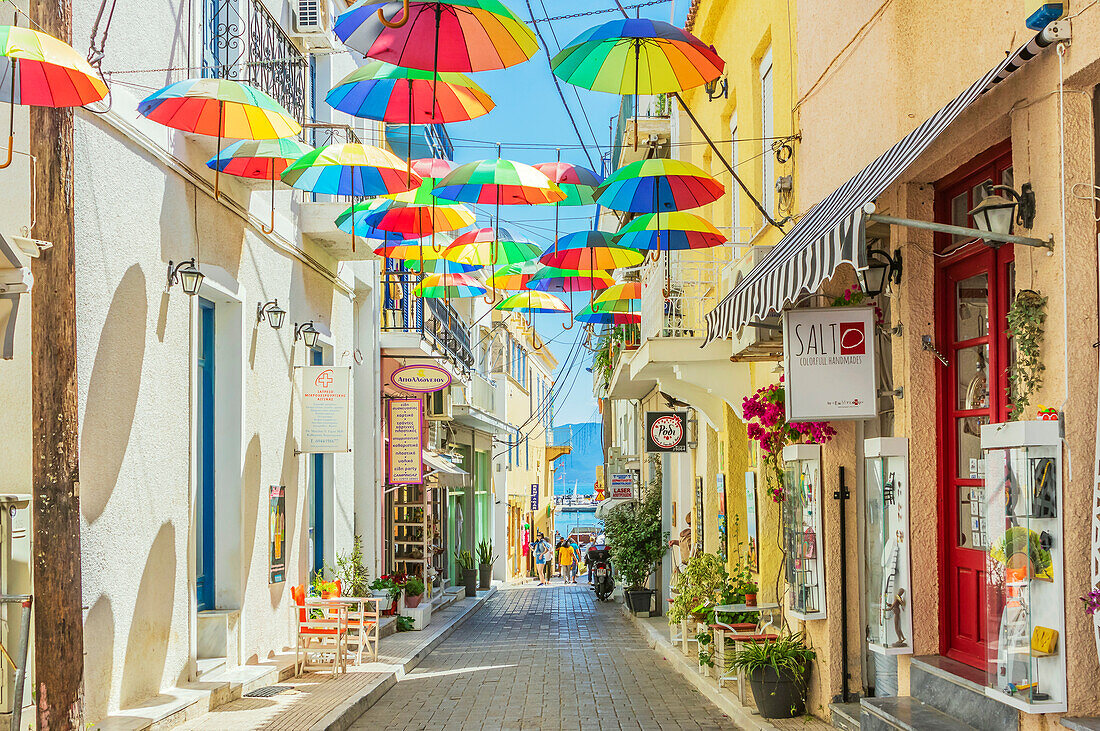  Aegina is a Greek island in the Saronic Gulf in the western Aegean Sea, also called the Gulf of Aegina. The island is located 25 km southwest of Athens. Here a street with colorful umbrellas 