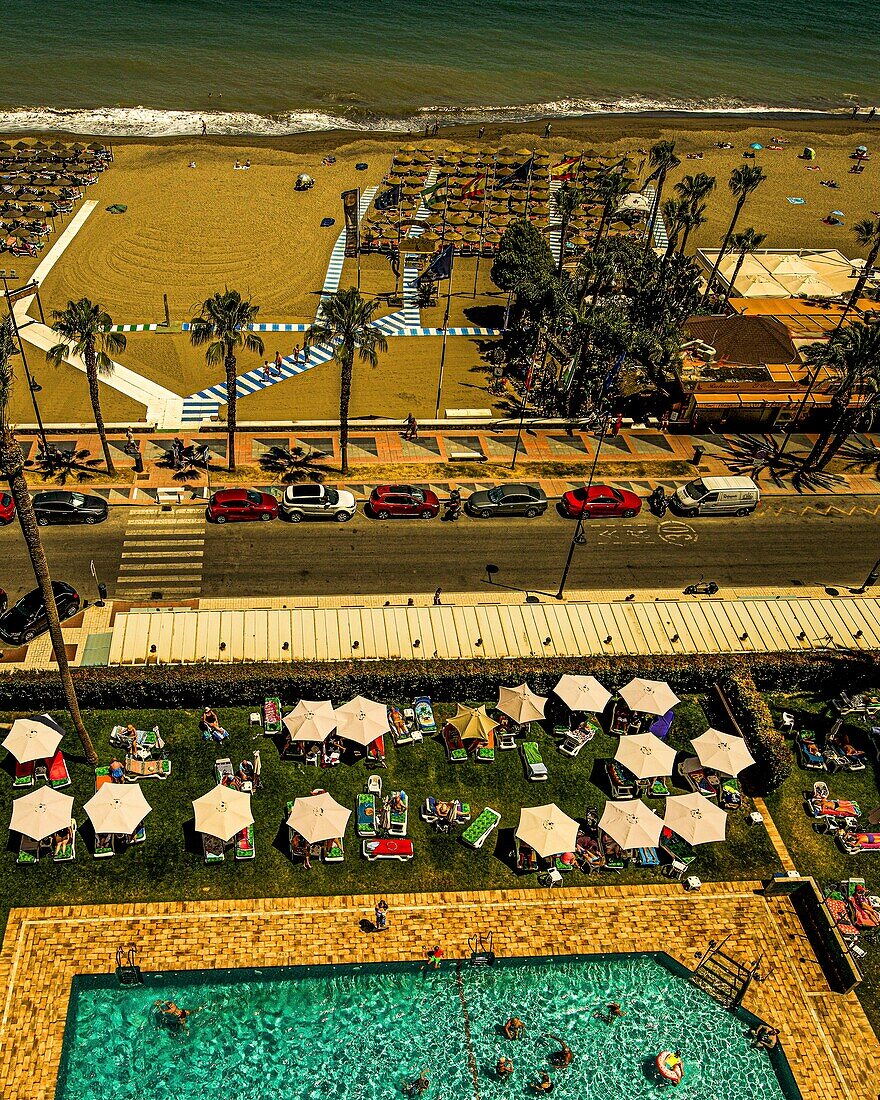  View from Apartamentos Bajondillo to hotel pool, parasols, Paseo Maritimo, El Bajondillo beach and the sea, Torremolinos, Costa del Sol, Spain 