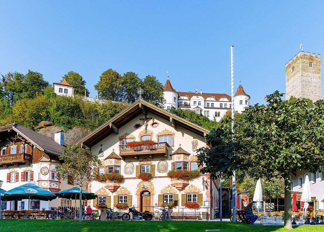  Historic market square with Haus zum Sailer (guest information) with Lüftlmalerei and view of Neubeuern Castle in Neubeuern in Chiemgau in Upper Bavaria in Germany 