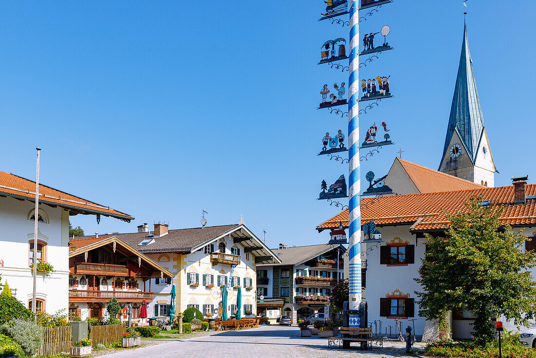  Market square with historic house Schusterhäusl, maypole and church Maria Himmelfahrt in Törwang am Samerberg in Chiemgau in Upper Bavaria in Germany 