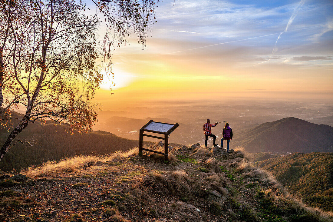 Two hikers enjoying the view, Oasi Zegna nature reserve in autumn, Biella province, Piedmont, Italy