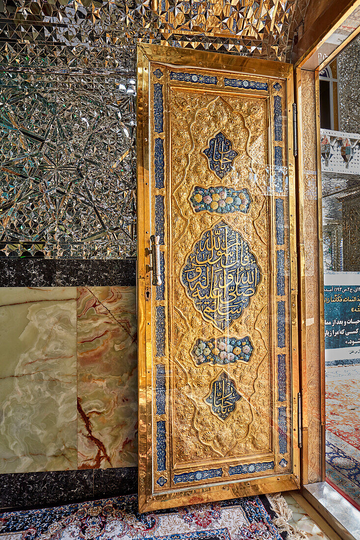 Golden door in Imamzadeh Mohammed Helal Shrine elaborately decorated with intricate embossing and Islamic calligraphy. Aran o Bidgol, Iran.