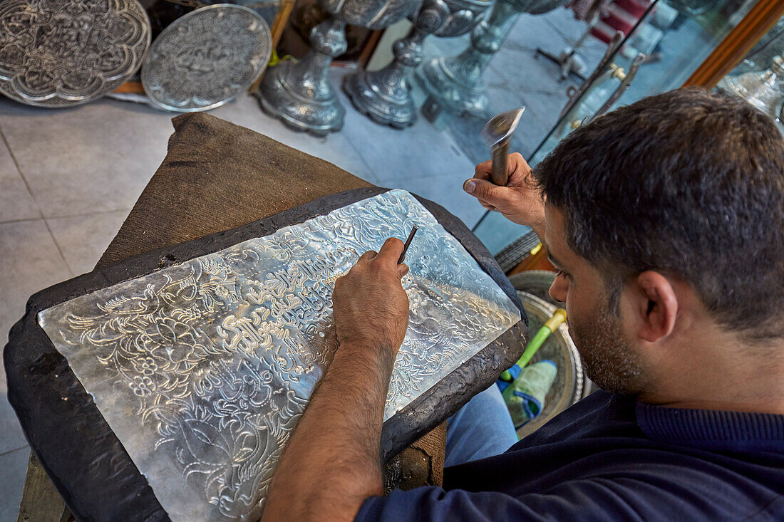  Qalamzani- oder Ghalamzani-Künstler (traditionelle iranische Metallgravurkunst) arbeitet in einem Kunsthandwerksladen. Isfahan, Iran. 