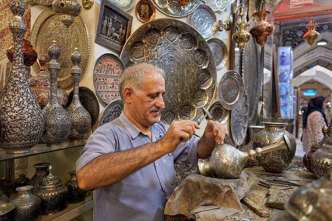  Qalamzani- oder Ghalamzani-Künstler (traditionelle iranische Metallgravurkunst) arbeitet in seinem Kunsthandwerksladen im Großen Basar. Isfahan, Iran. 