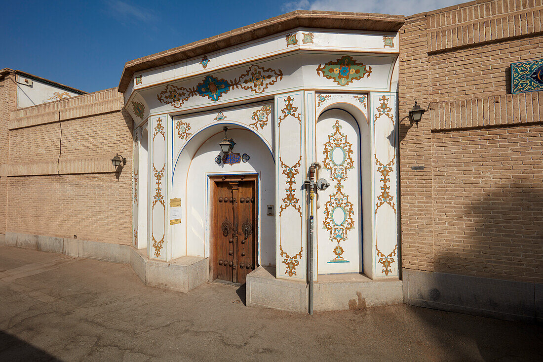 Kunstvolles Eingangstor mit alter Holztür des historischen Mollabashi-Haus in Isfahan, Iran.