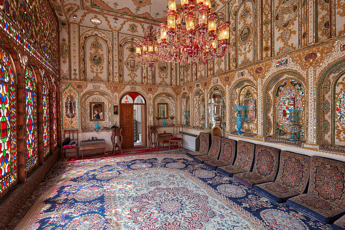  Innenansicht des Shahneshin (ein spezieller Empfangsraum) mit großen farbenfrohen Buntglasfenstern im historischen Mollabashi-Haus in Isfahan, Iran. 