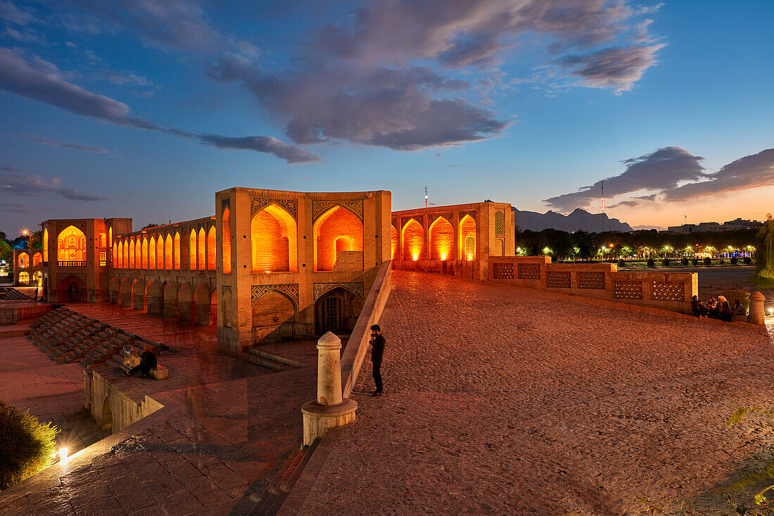  Blick auf die beleuchtete Khaju-Brücke aus dem 17. Jahrhundert über den Zayanderud-Fluss während der Trockenzeit mit trockenem Flussbett. Isfahan, Iran. 