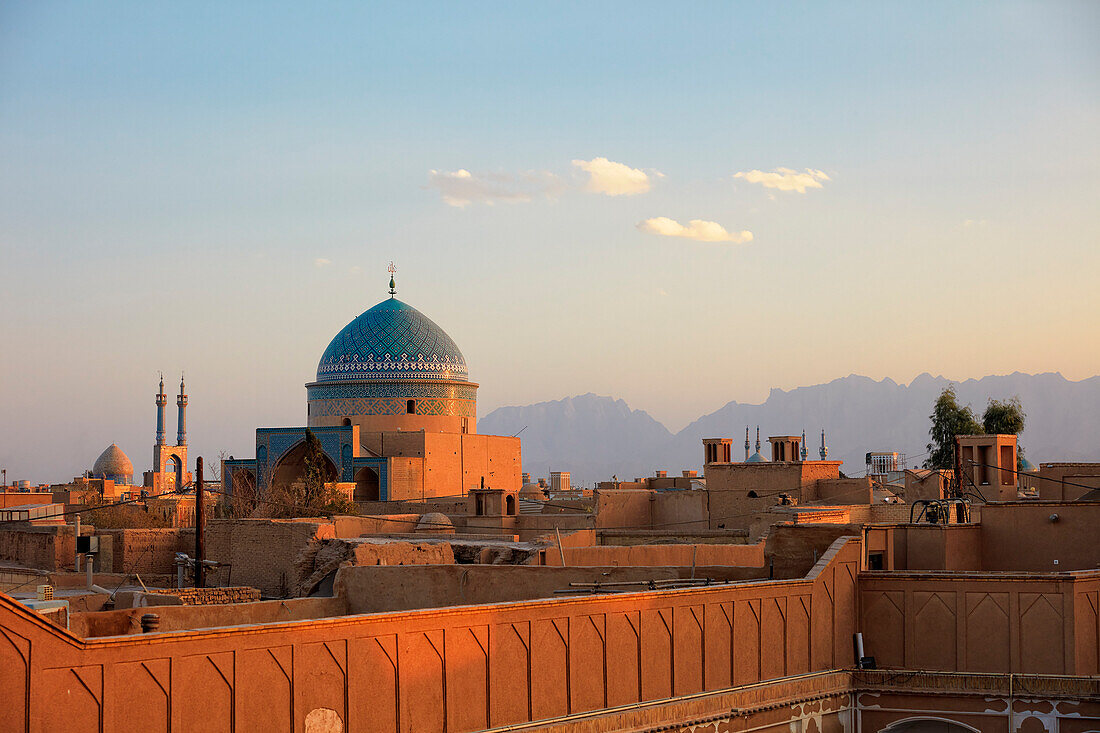 Blick vom Dach des Seyed Rokn Addin-Mausoleum (14. Jahrhundert) mit seiner wunderschönen blau gefliesten Kuppel, die von der untergehenden Sonne beleuchtet wird. Yazd, Iran.