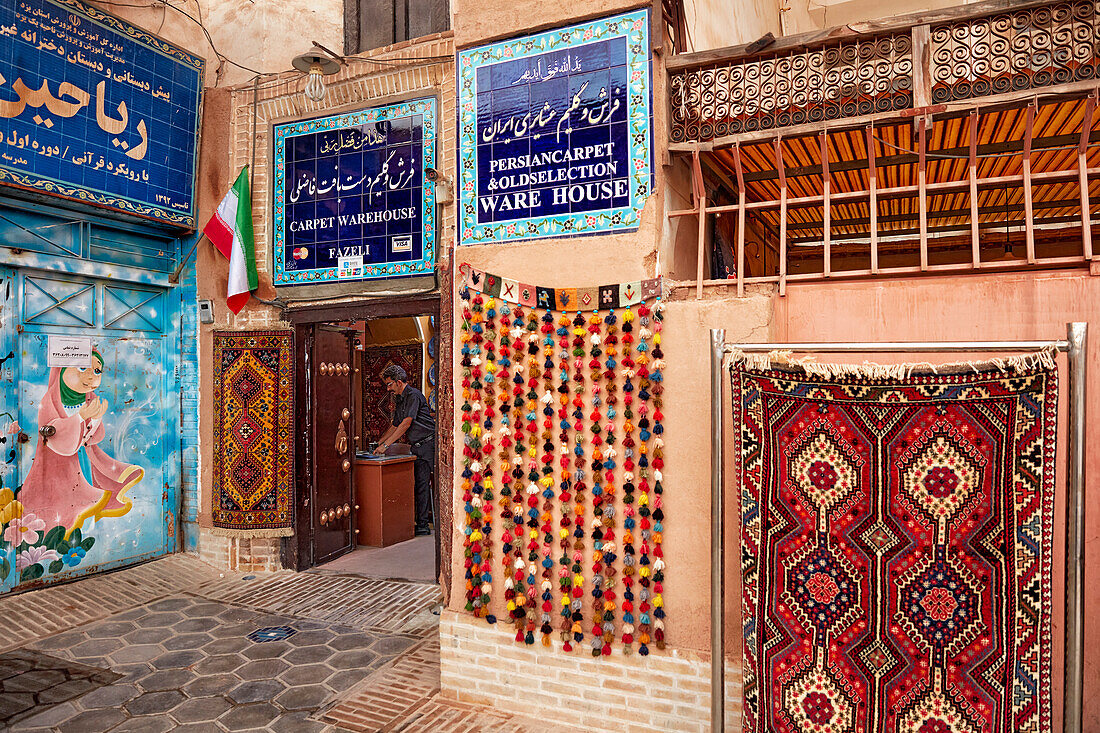  Farbenfrohe Teppiche vor dem Schaufenster des Fazeli Carpet Warehouse in der Altstadt von Yazd, Iran. 