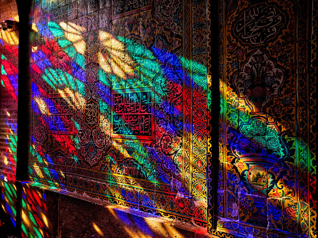 A play of light from multi-colored stained-glass windows inside the 19th century Nasir al-Mulk Mosque, aka the Pink Mosque. Shiraz, Iran.