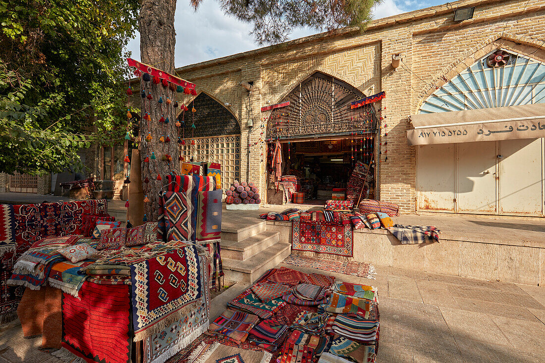 Colorful rugs displayed at the entrance to a handicraft shop in Vakil Bazaar. Shiraz, Iran.