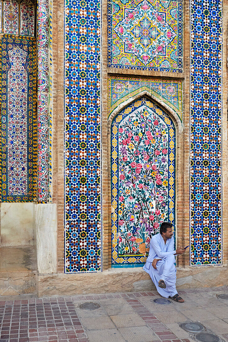 Iranian man wearing traditional costume sits at the 18th century Vakil Mosque in Shiraz, Iran.