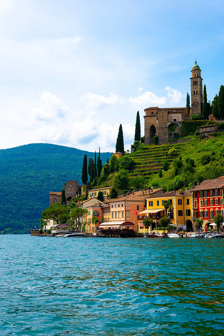 Haus und Kirche auf einer Bergkette an einem sonnigen Sommertag am Ufer, Luganersee in Morcote, Lugano, Tessin, Schweiz.