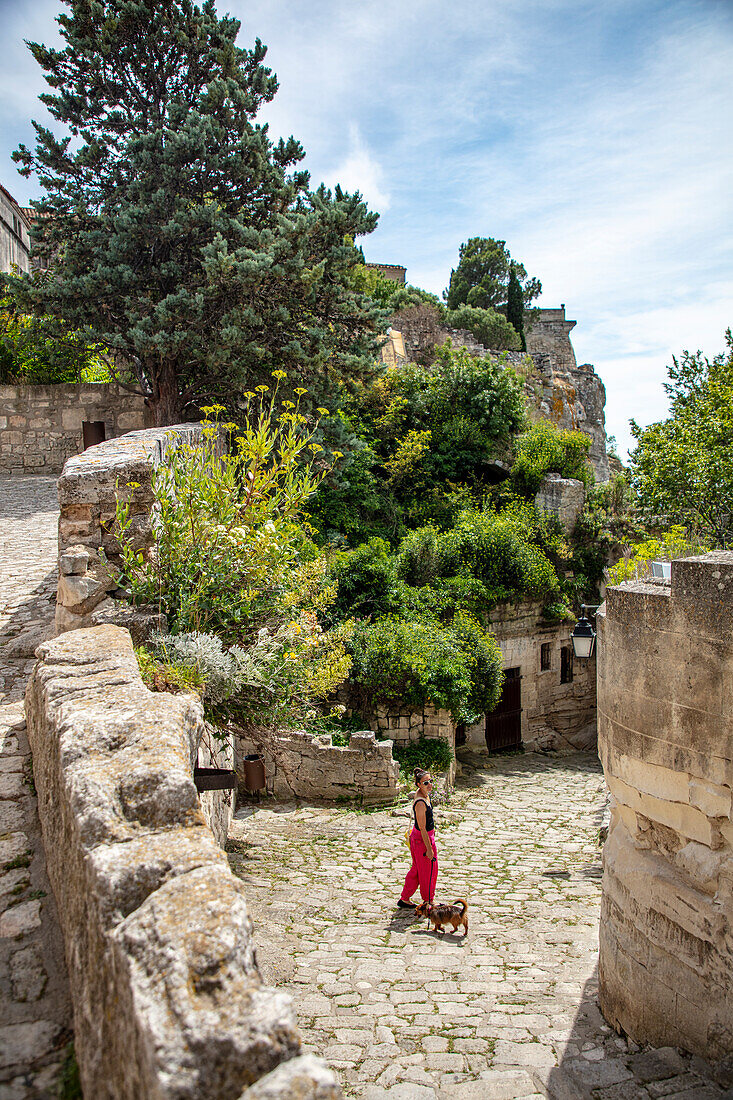  Woman with dog in an alley in Les Baux de Provence, Provence-Alpes-Côte d&#39;Azur, France 