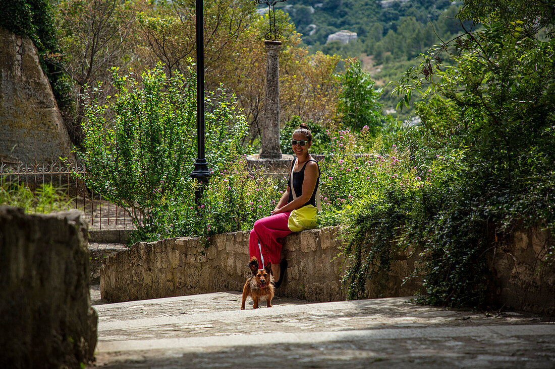  Woman with dog in an alley in Les Baux de Provence, Provence-Alpes-Côte d&#39;Azur, France 