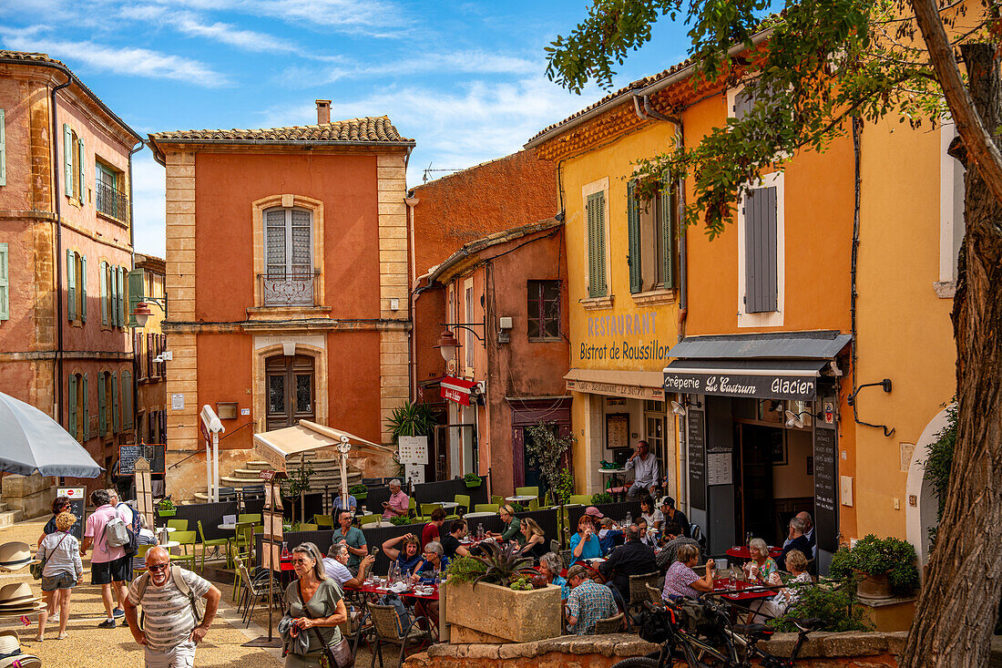 Restaurant und Touristen in der Altstadt von Roussillon, Département Vaucluse, Provence-Alpes-Côte d’Azur, Frankreich