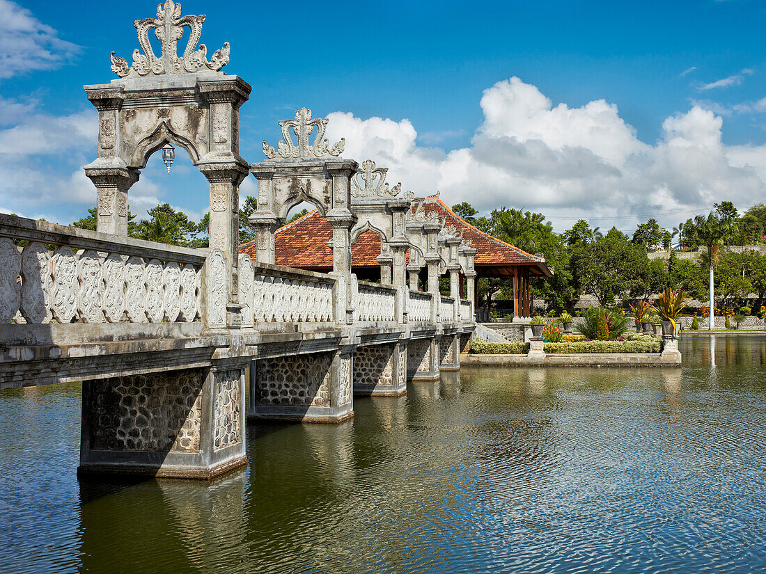 Walking bridge leading to a resting pavilion. Ujung Water Palace (Taman Ujung). Karangasem Regency, Bali, Indonesia.