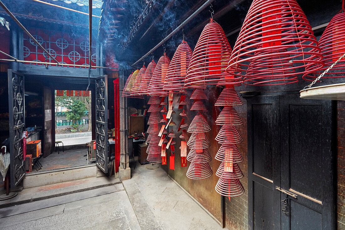  Brennende Weihrauchspiralen hängen an Geländern im Tin Hau-Tempelkomplex. Yau Ma Tei, Kowloon, Hongkong, China. 