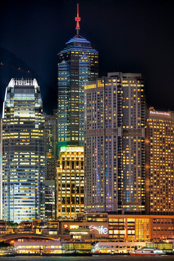 Modern high-rise buildings at Central Waterfront illuminated at night. Hong Kong, China.