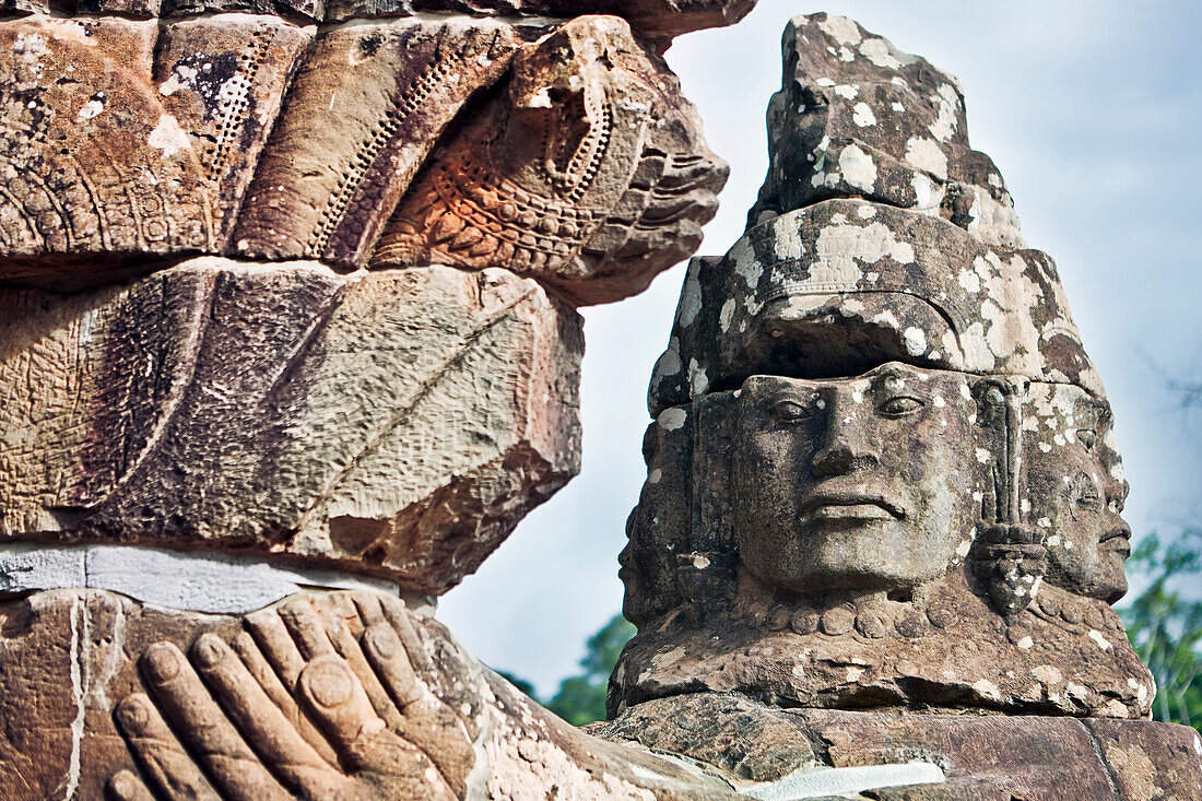 Large carved stone faces at the South Gate to the Angkor Thom. Angkor Archaeological Park, Siem Reap Province, Cambodia.