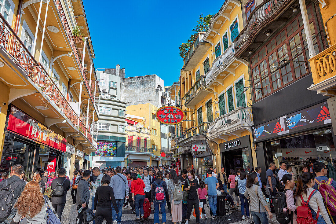 Crowded narrow street in the historic center of Macau city, China.