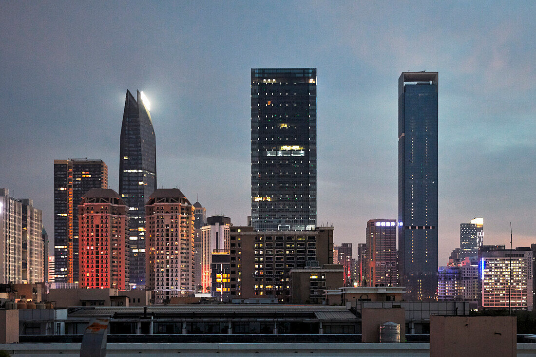  Hochhäuser im Bezirk Futian, beleuchtet in der Abenddämmerung. Shenzhen, Provinz Guangdong, China. 