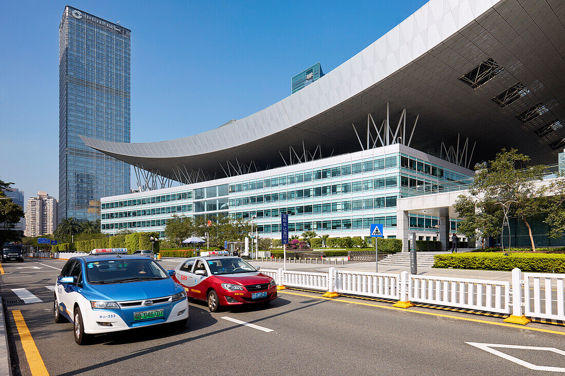 Taxi cabs pass by the Shenzhen Civic Center. Shenzhen, Guangdong Province, China.