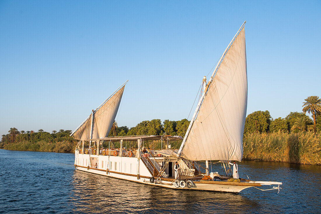 Dahabeah Schiff unter Segeln, Passagier-Flussschiff der Lazuli-Flotte, auf dem Nil bei Sonnenuntergang, bei Assuan, Ägypten, Nordostafrika