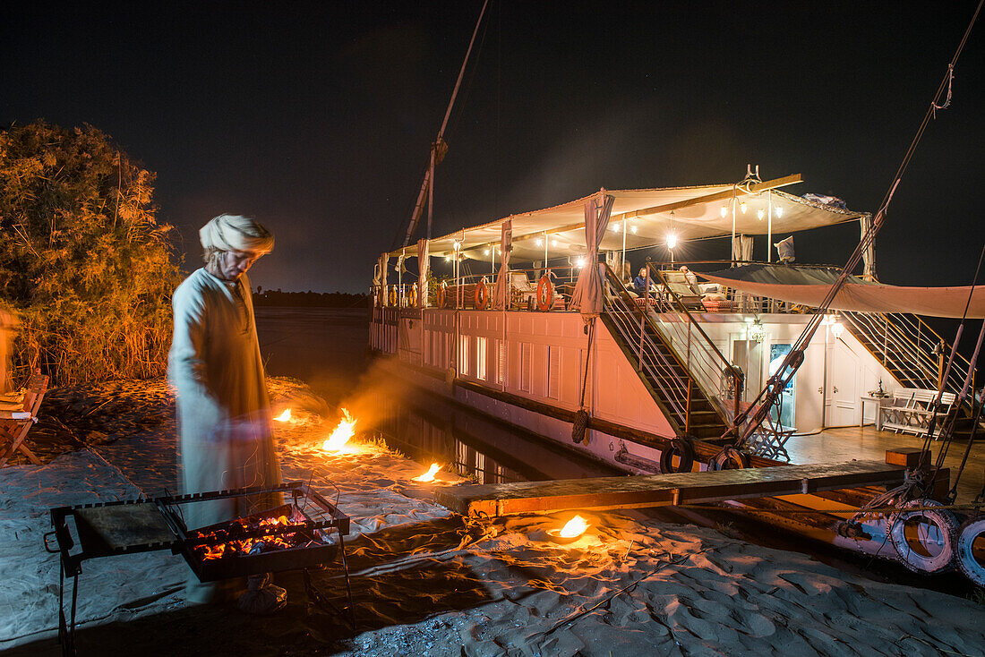 Dinner on the beach with the Dahabeah, passenger river boat of the Lazuli fleet, moored on the bank of the Nile river, Egypt, northeast Africa