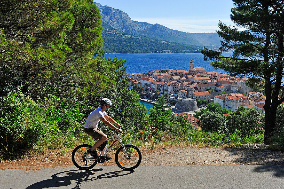 Radfahrer über der Altstadt von Korcula Stadt, Insel Korcula, bei Dubrovnik, Dalmatien, Kroatien, Südosteuropa