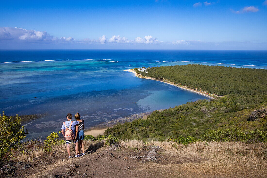  Couple enjoying view over lagoon and coast halfway through hike to Le Morne mountain, Le Morne, Rivière Noire, Mauritius, Indian Ocean 