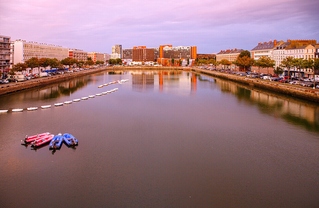  Bassin du Commerce with training boats of the sailing school and view of the Quai d&#39;Angoulême (Angouleme) with Hotel Mercure Le Havre Centre and building of the radio station NRJ in Le Havre at sunset on the Alabaster Coast (Côte d&#39;Albatre, Cote d&#39;Albatre) in the Seine-Maritime department in the Normandy region of France 